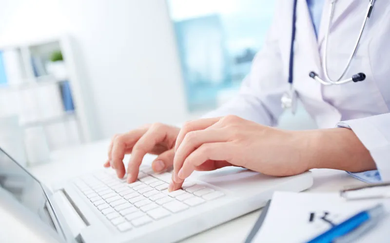 Doctor reviewing plan information on a laptop