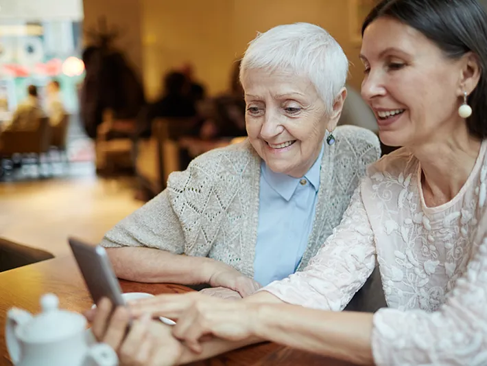 Two women exploring benefits on a tablet